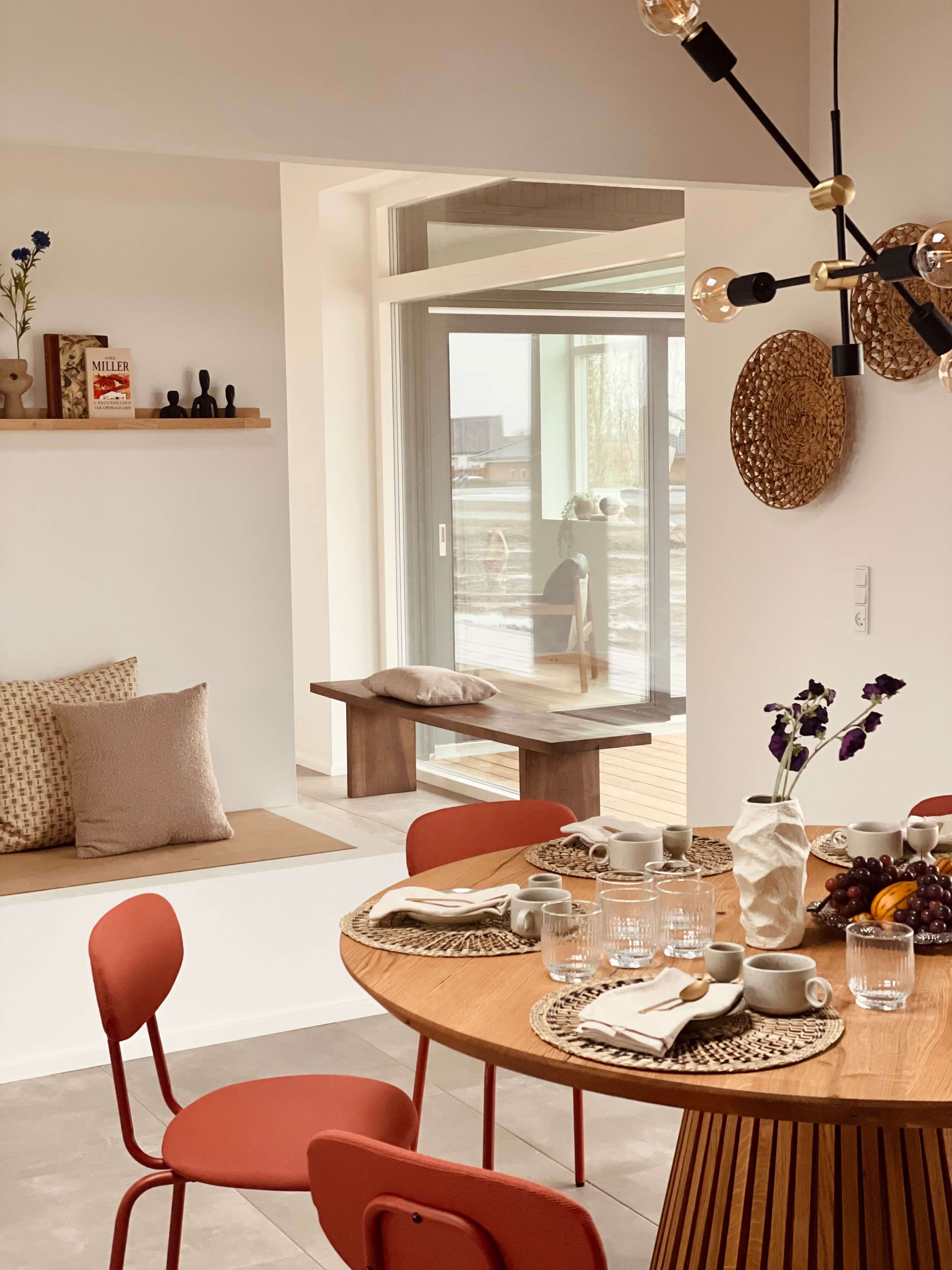 Rundbord i naturfarver med røde stole