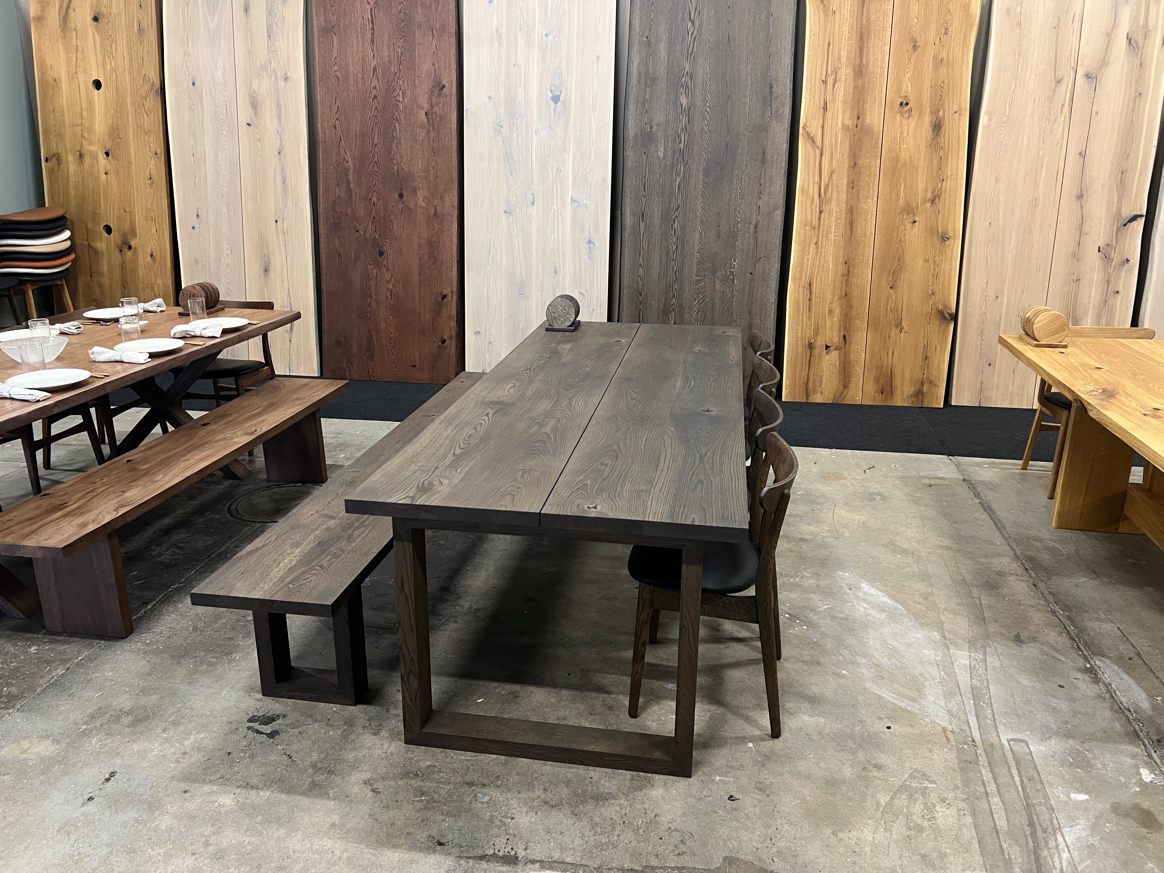 Sortolieret plankebord i vores showroom med stole og bænk